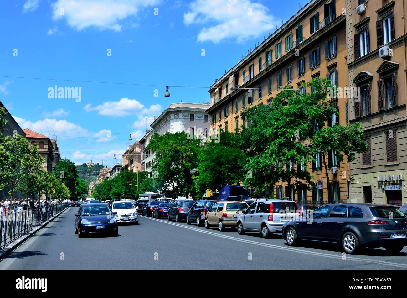 Varie tipologie / make autovetture parcheggiate in fila e edifici commerciali / residenziali vicino a strada, Roma, Italia, Europa Foto Stock