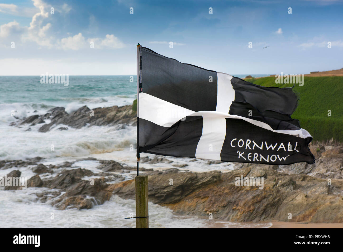 Un St bandiera di Pirano che fluttua nel vento sulla costa a Fistral in Newquay Cornwall. Foto Stock