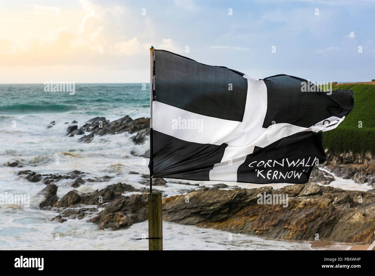 Un St bandiera di Pirano che fluttua nel vento sulla costa a Fistral in Newquay Cornwall. Foto Stock