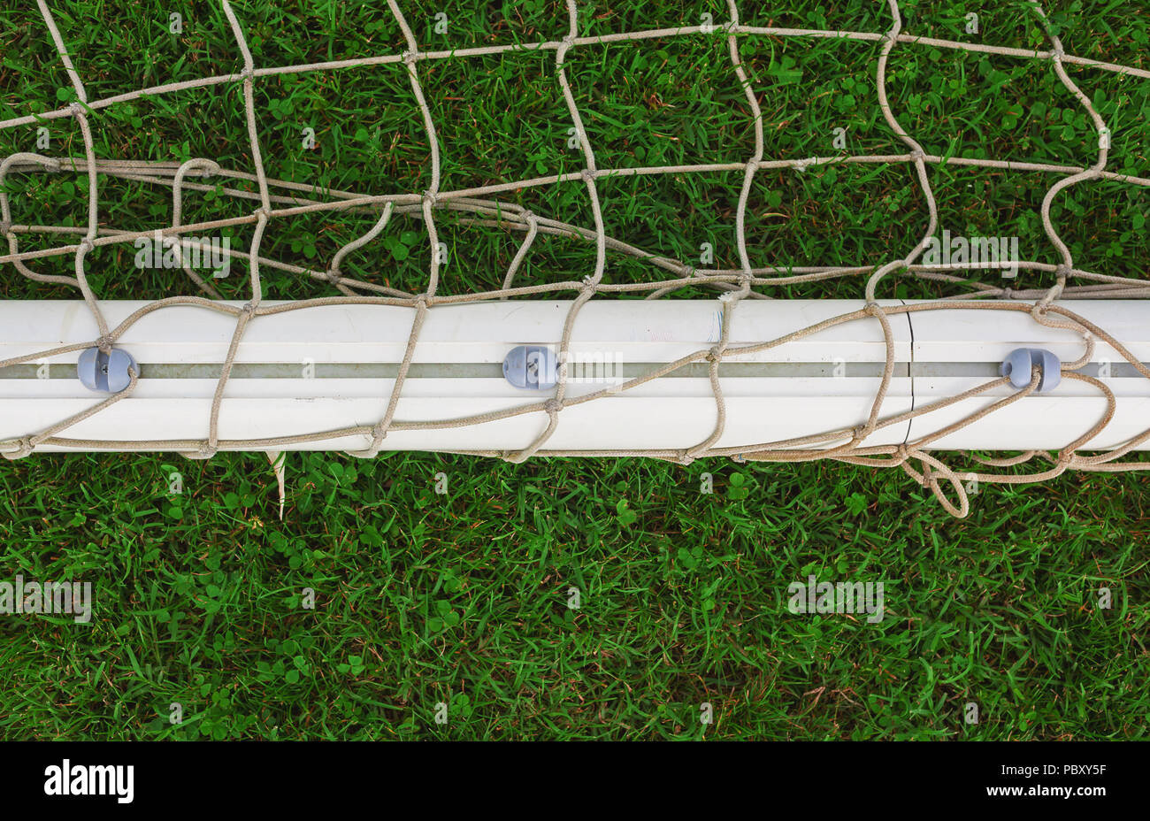 Vista sul net e il telaio di un obiettivo di calcio sul prato verde. Foto Stock