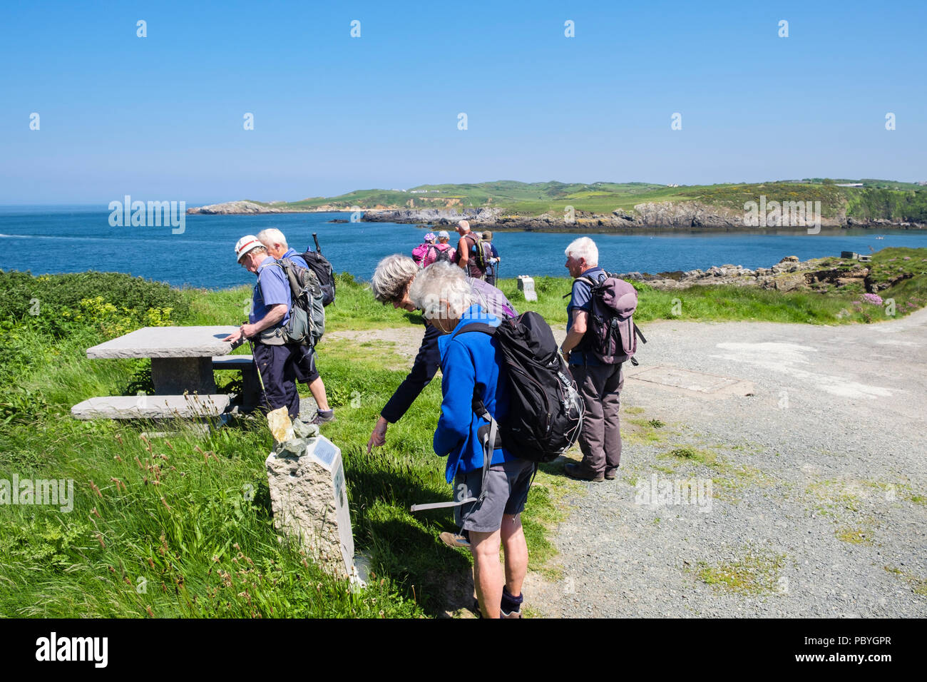 Gli escursionisti la lettura di informazioni locali segni sul sentiero costiero intorno a Cemaes Bay, Isola di Anglesey, Galles, Regno Unito, Gran Bretagna Foto Stock