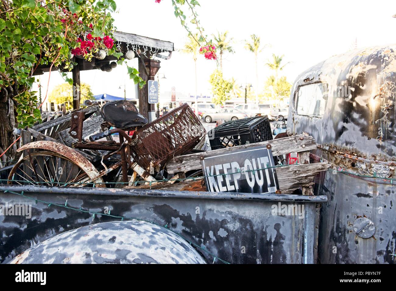 Un vecchio carrello arrugginito si siede fuori con il letto pieno di spazzatura arrugginito Foto Stock