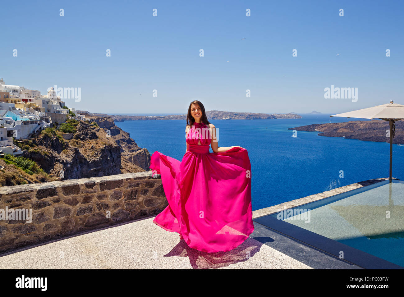 Giovane donna in abito rosso sull isola di Santorini, Grecia Foto Stock