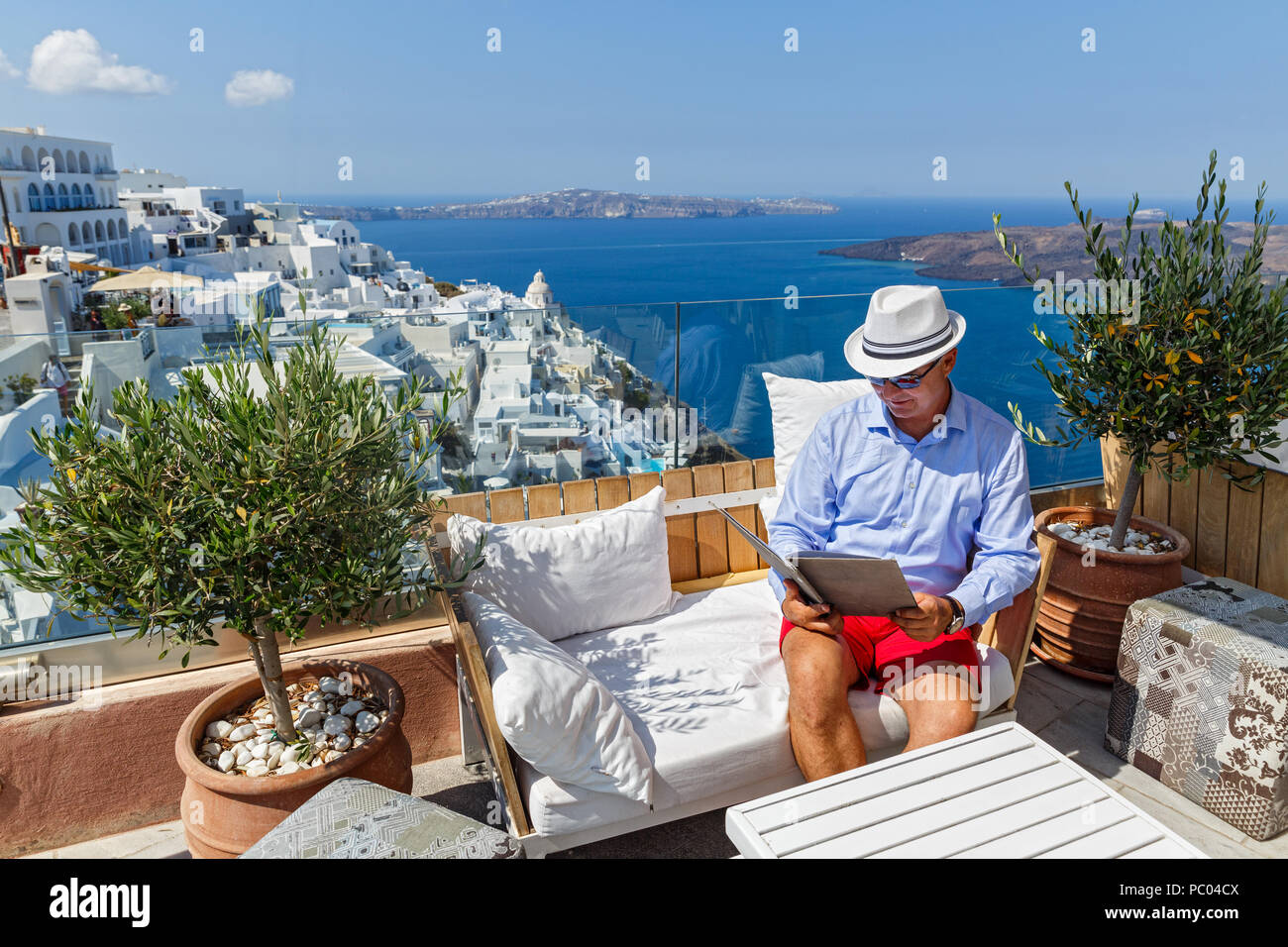 Uomo in un ristorante in riva al mare a guardare il menu e fa un ordine alimentare Foto Stock