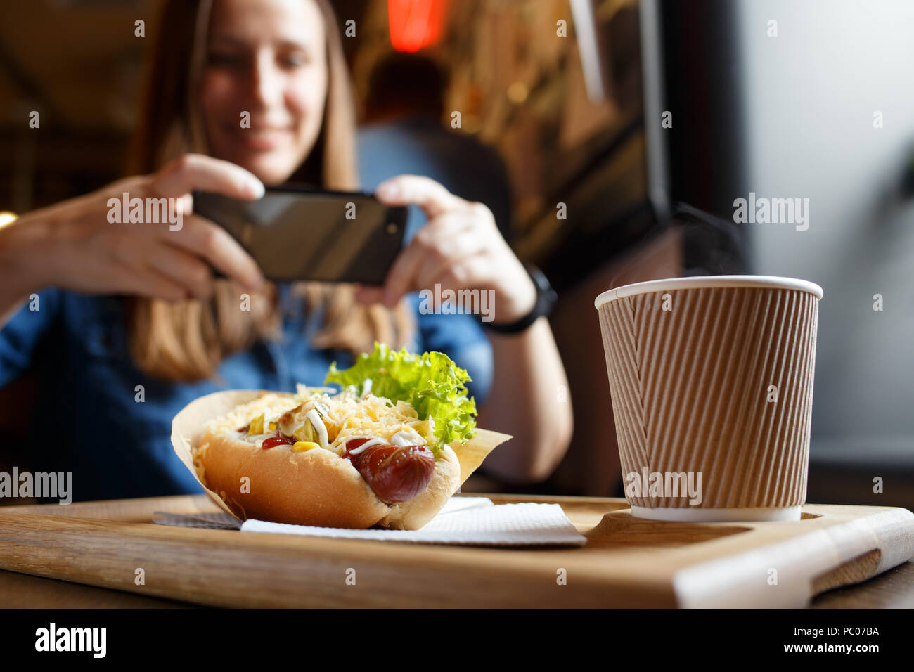 Giovane donna prendendo la foto del suo pranzo in cafe Foto Stock