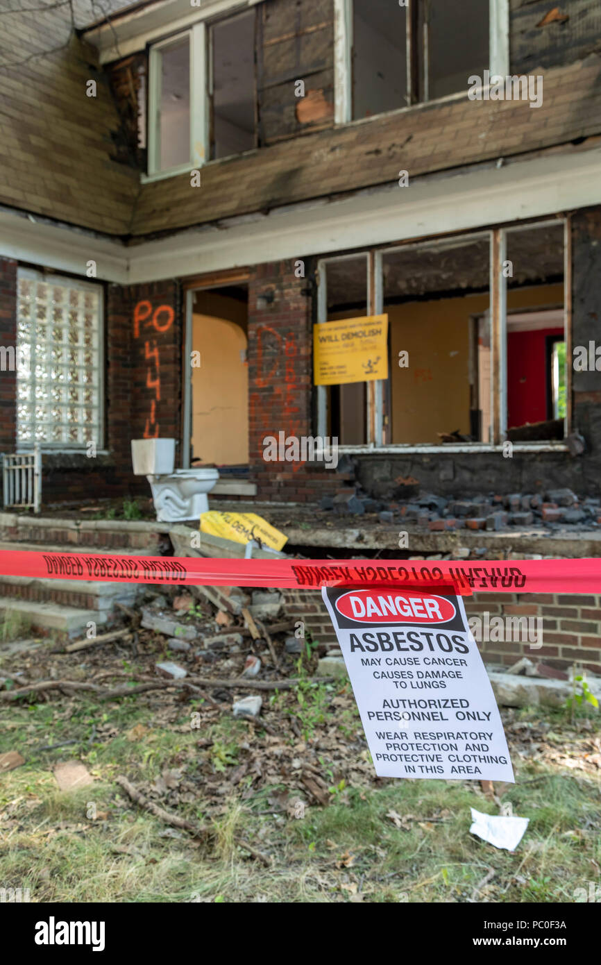 Detroit, Michigan - un avviso circa l'esposizione all'amianto pende al di fuori di una casa abbandonata essendo preparato per la demolizione. La proprietà sarà utilizzato per un Foto Stock