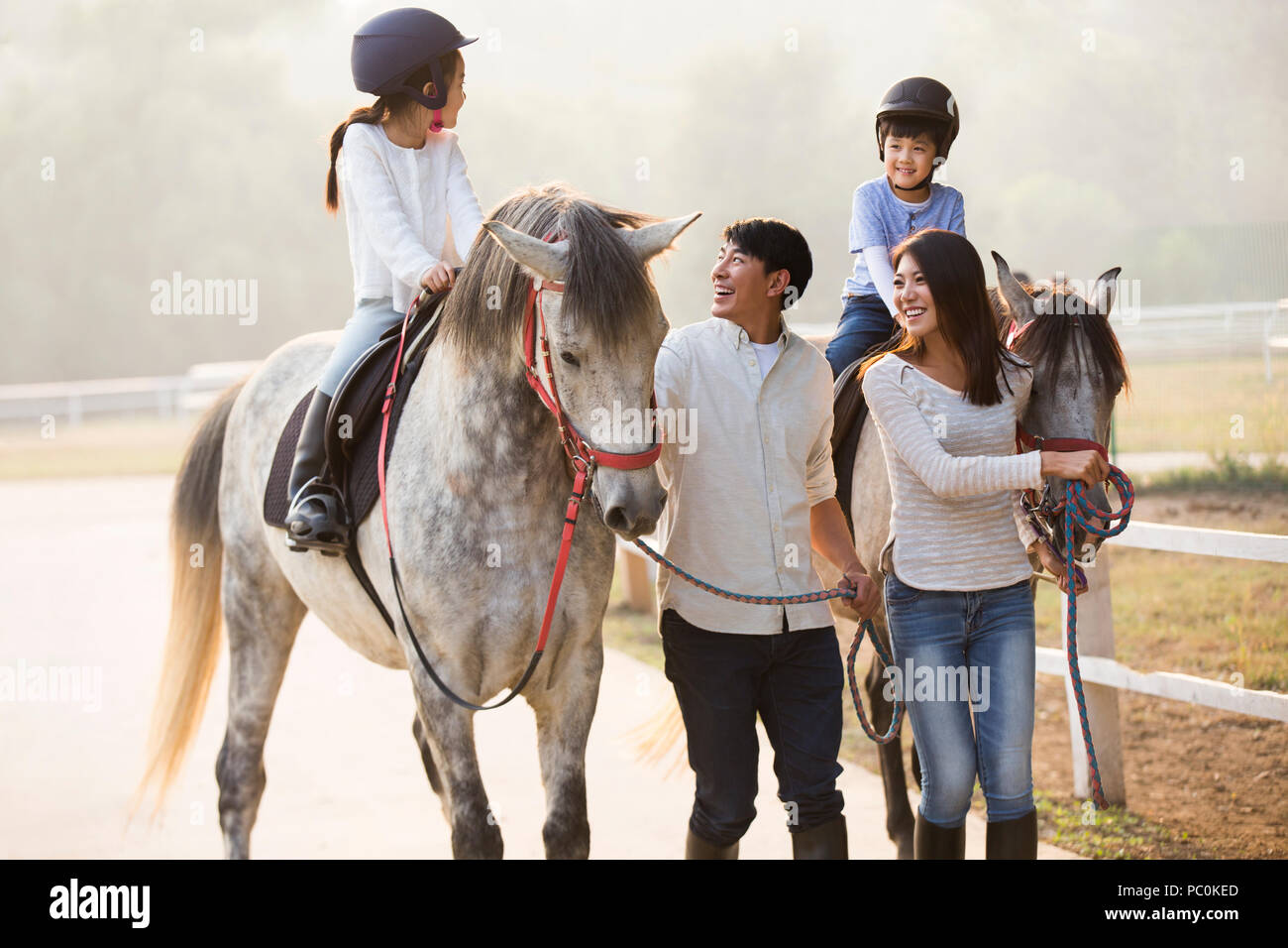 Allegro giovane famiglia cinese a cavallo Foto Stock