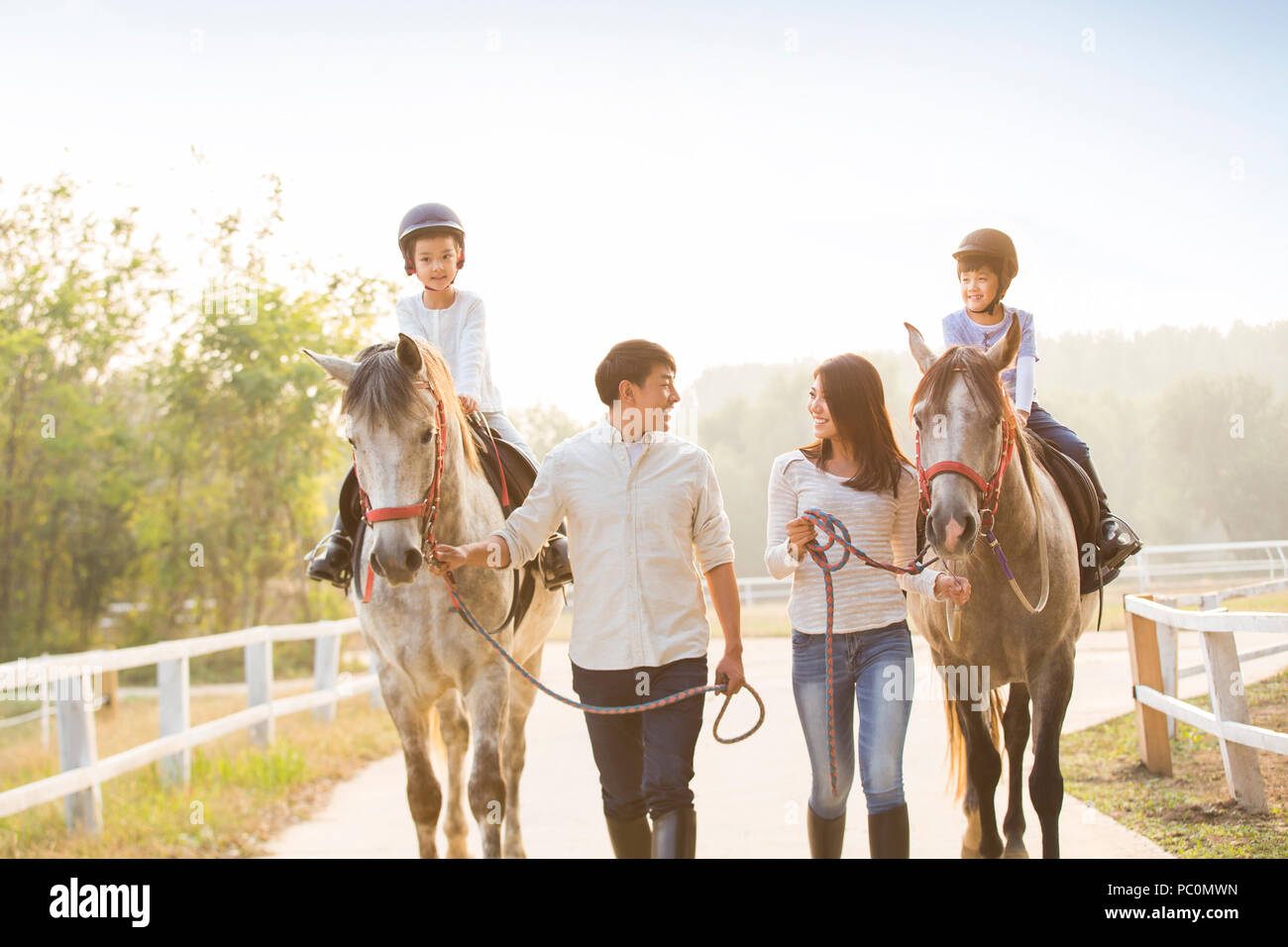 Allegro giovane famiglia cinese a cavallo Foto Stock