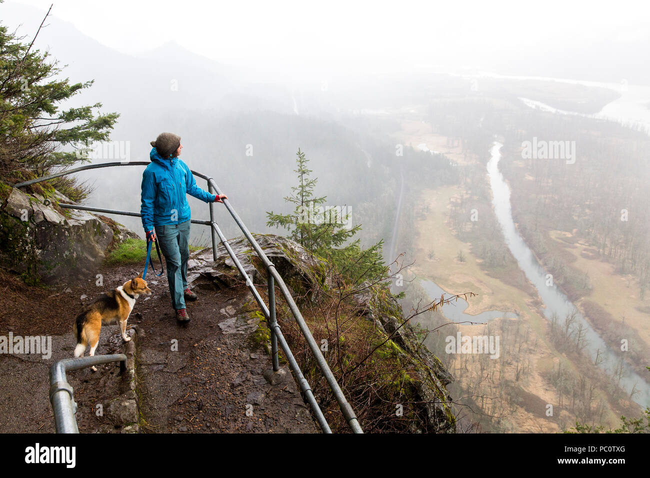 Una donna passeggiate con il suo cane su Beacon Rock in Columbia River Gorge. Foto Stock