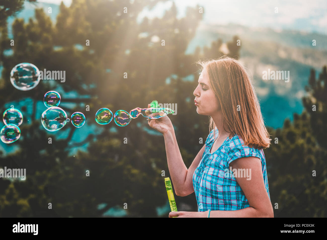 Ritratto di giovane donna fare bolle di sapone in natura Foto stock - Alamy