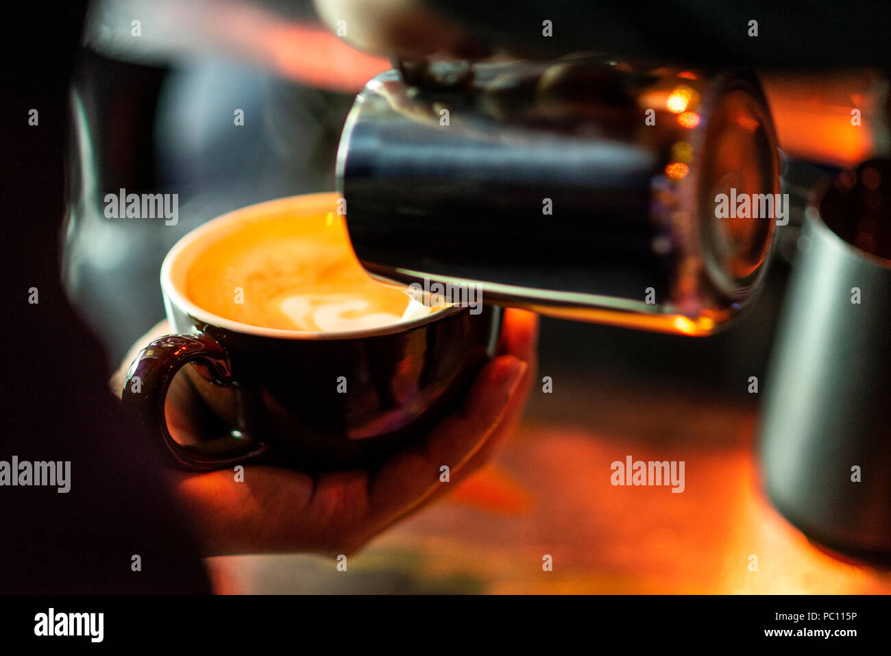 La preparazione di caffè espresso close up dettaglio versando il latte con caffetteria moderna macchina Foto Stock