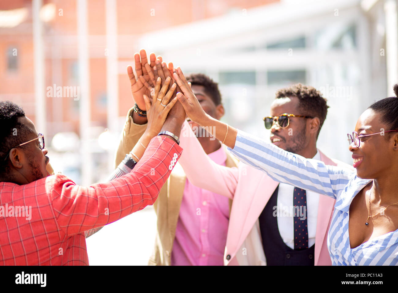 Il team di Business mostra la sua amicizia cordiale giovani africani unendo le loro mani Foto Stock
