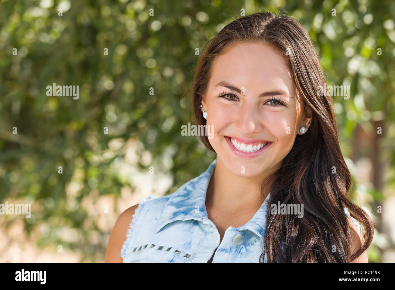 Attraente sorridente razza mista ragazza ritratto all'esterno. Foto Stock