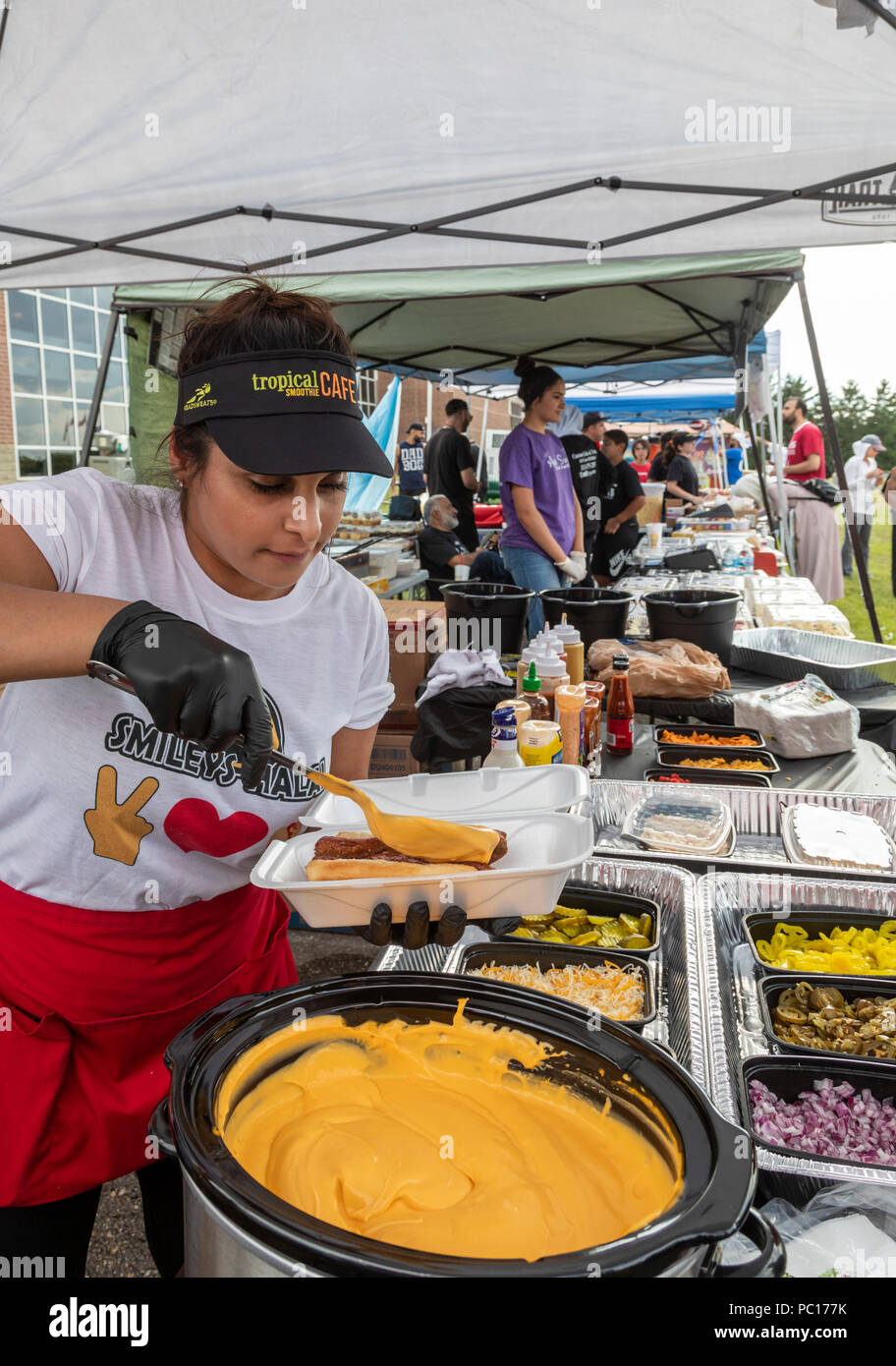 Dearborn, Michigan - Una donna serve una halal hot dog alla Smileys carne halal stand a un politico musulmano rally. La carne halal è preparata in conformità Foto Stock