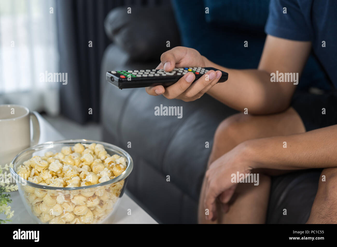 Mano con un telecomando del televisore Foto Stock