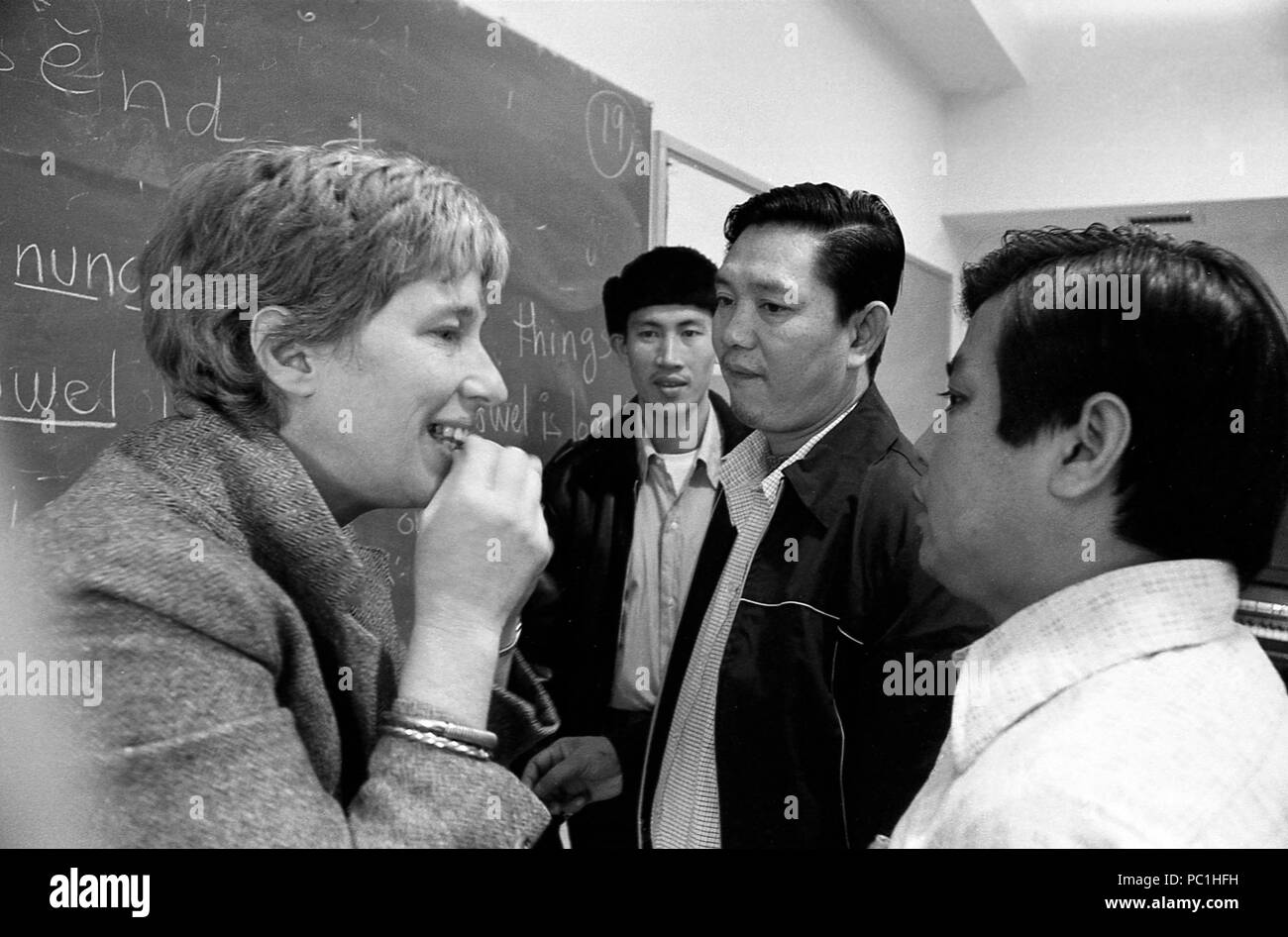 Gli immigrati l apprendimento della lingua inglese. Insegnante aiutando i suoi studenti adulti di pronunciare parole in inglese, formando i suoni in modo corretto. Foto Stock