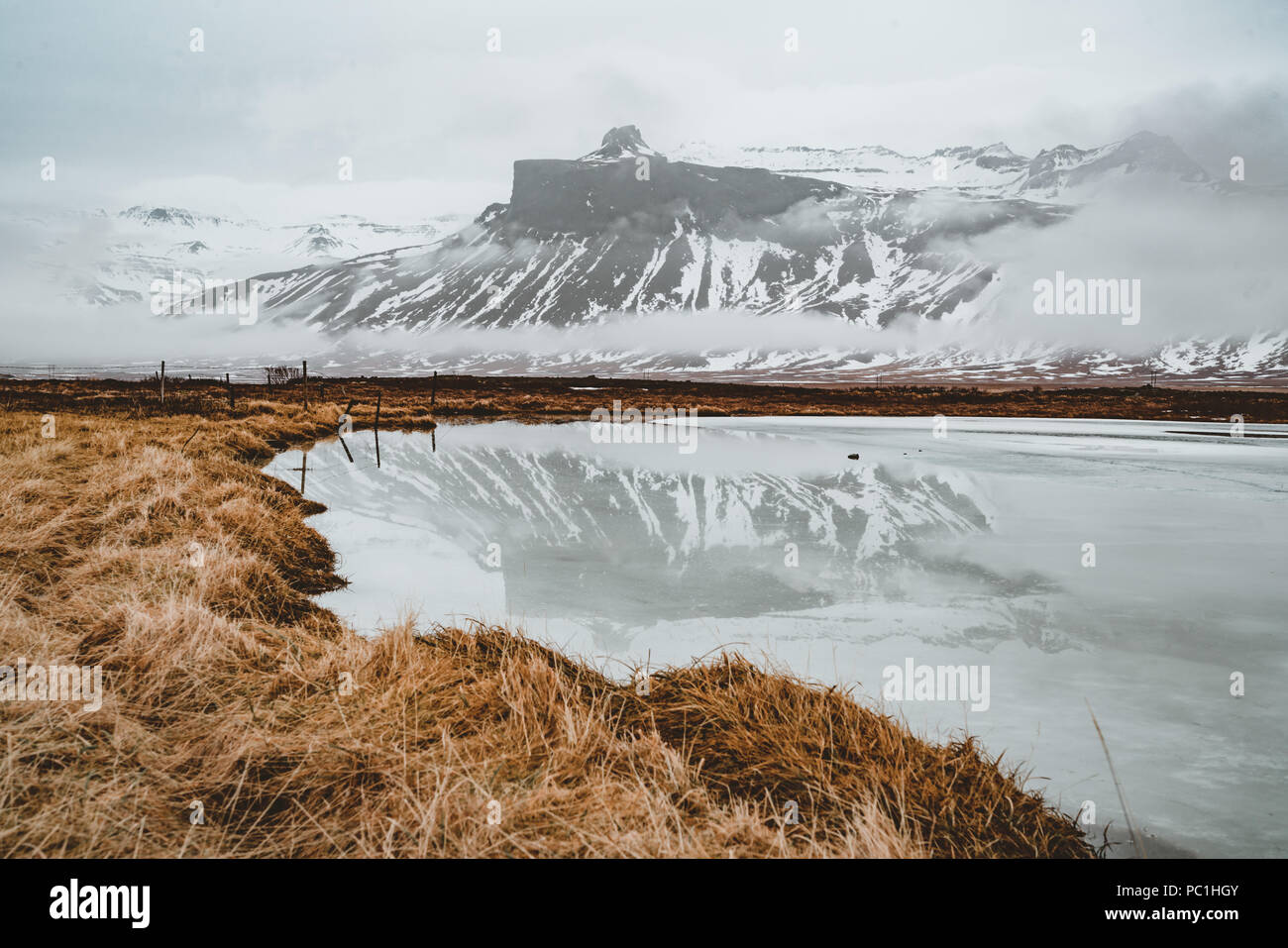 Islanda riflessione di montagna con ghiaccio e nuvole. Penisola Snaesfellnes Foto Stock