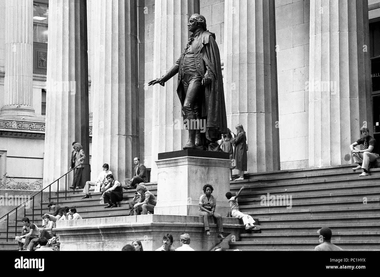La gente seduta sui gradini della Federal Hall di Manhattan, 1982. La statua di George Washington nella parte anteriore della Federal Hall National Memorial. Foto Stock