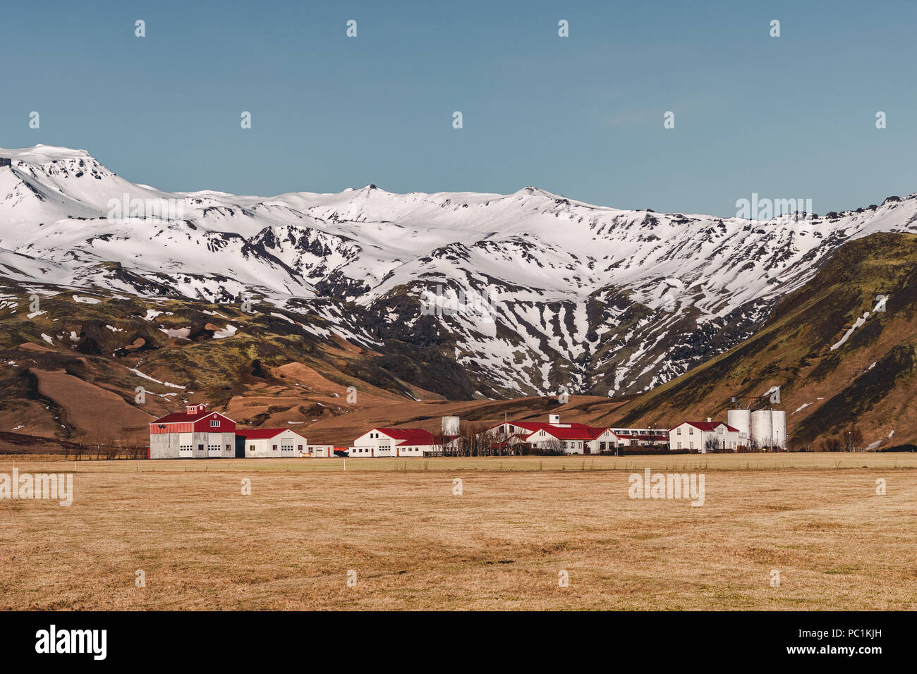 Tipico paesaggio islandese con case bianco rosso tetto contro le montagne del piccolo villaggio nel sud dell'Islanda. Foto Stock