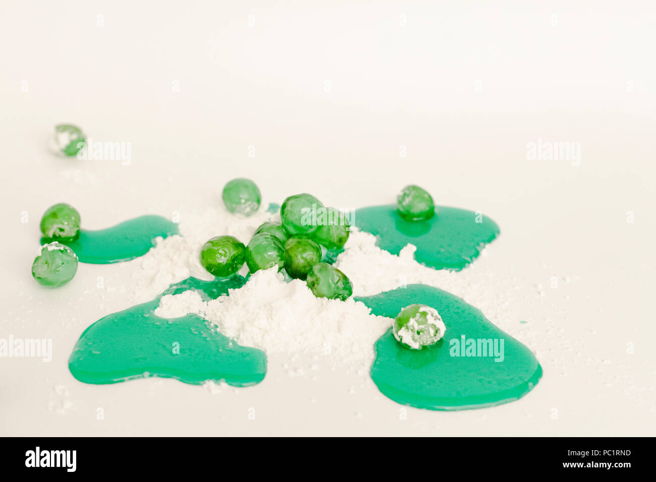 Sweet Food preparazione: verde e sciroppo di ciliegie candite con lo zucchero a velo, su uno sfondo bianco. Foto Stock