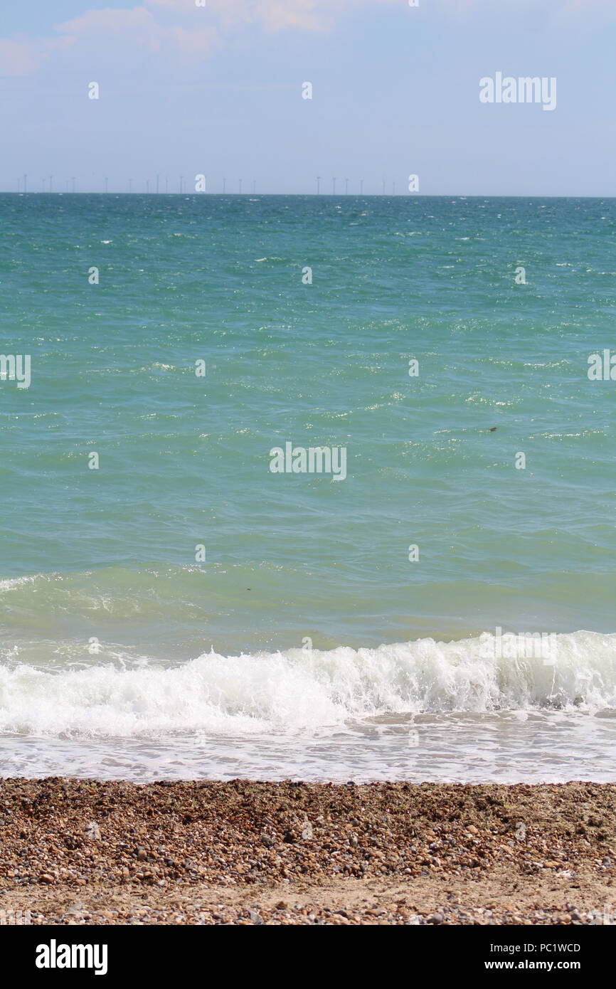 Marea sulla spiaggia di ciottoli in Goring-da-mare Foto Stock