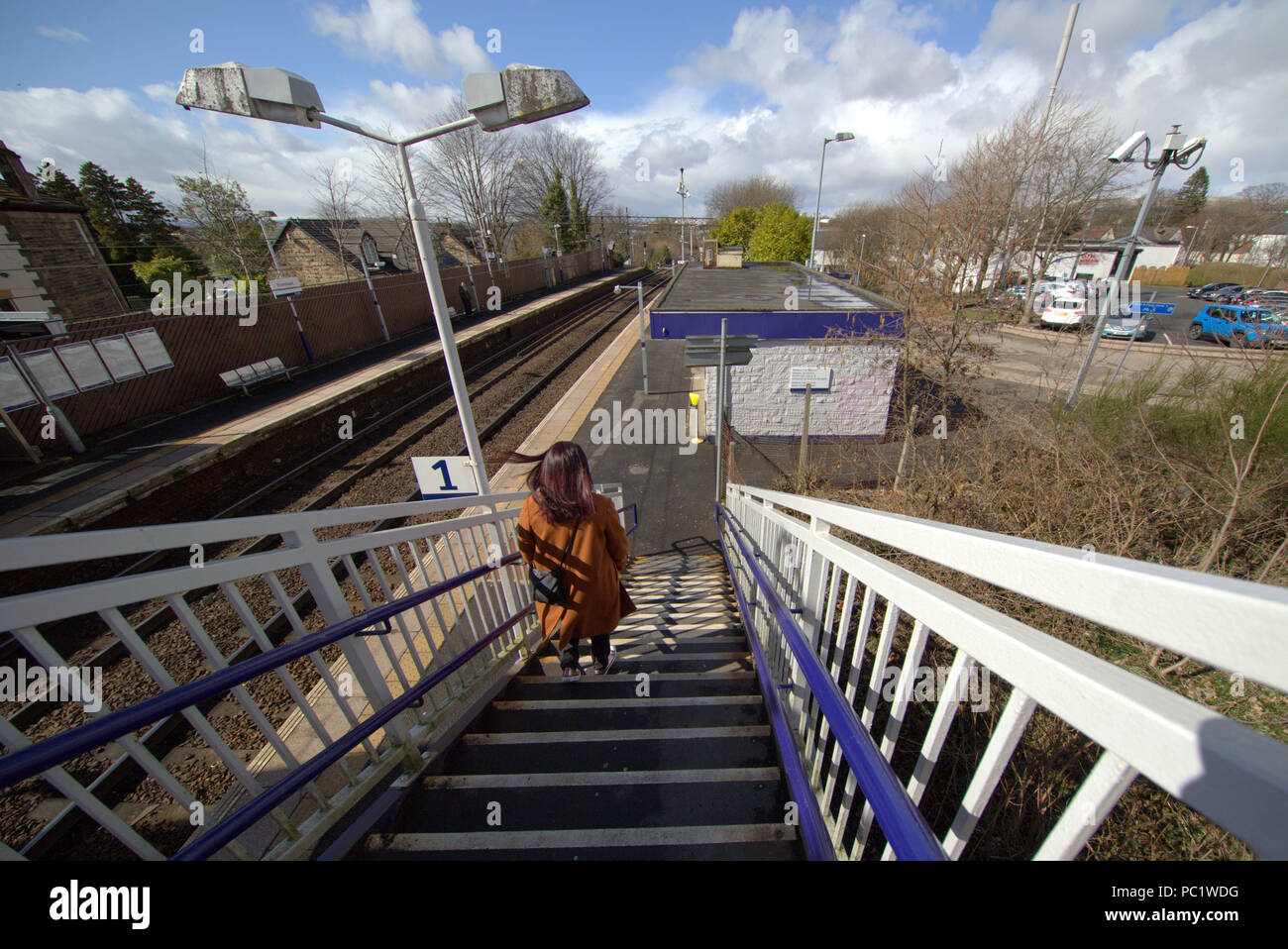 Il passeggero discesa delle scale in Drumchapel stazione ferroviaria in privato sistema di alloggiamento di drumchapel in Glasgow Foto Stock