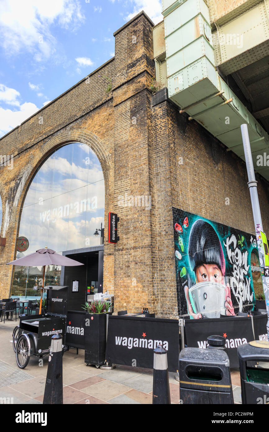 Esterno di Wagamama Clink Street ristorante giapponese sulla South Bank, Southwark, Londra SE1 costruito nella vecchia ferrovia archi su una giornata soleggiata con cielo blu Foto Stock