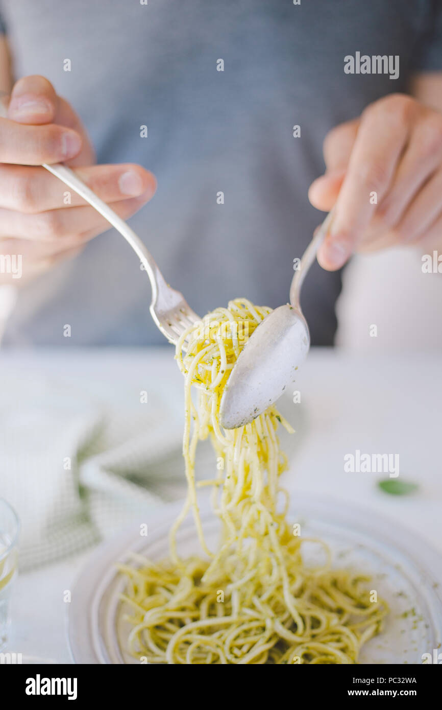 Giovane uomo mangiare gustosi piatti di pasta italiana. Mangiare sano concetto Foto Stock