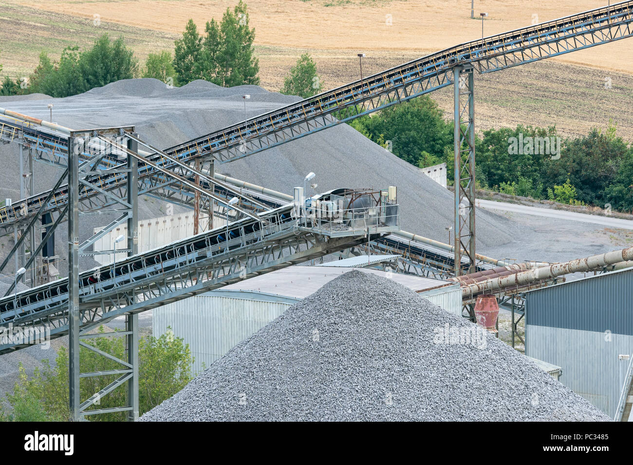 I trasportatori a nastro e le attrezzature minerarie in una cava. Cava di  pietra con nastri trasportatori e cumuli di pietre. Cave di pietre per le  opere di costruzione Foto stock -