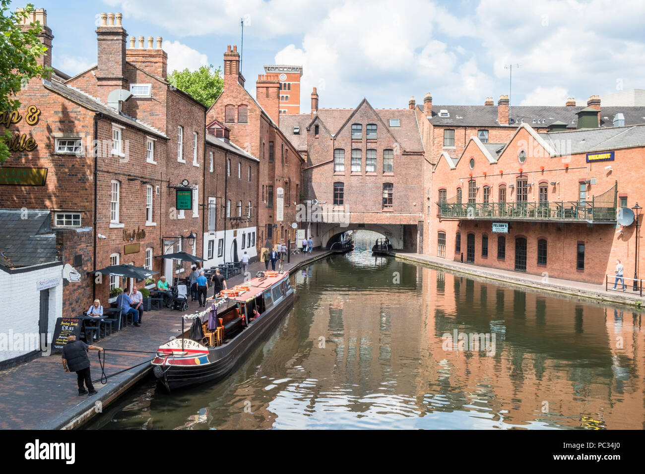 Un narrowboat sul Birmingham New Mainline Canal accanto al centro della città di Birmingham percorso con Broad Street Tunnel in distanza, Birmingham, Regno Unito Foto Stock