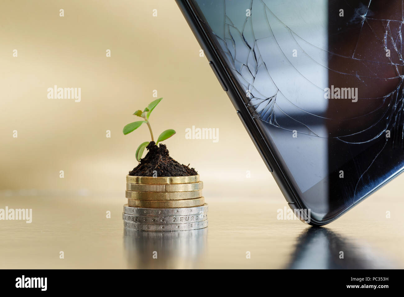Telefono Rotto display e golden e silver monete in terreno con pianta giovane. Riparare telefoni concetto di business Foto Stock