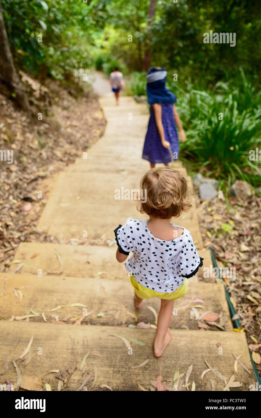 I bambini a piedi giù per la pista da Panjoo lookout per vedere Hinchinbrook Island, Cardwell QLD, Australia Foto Stock