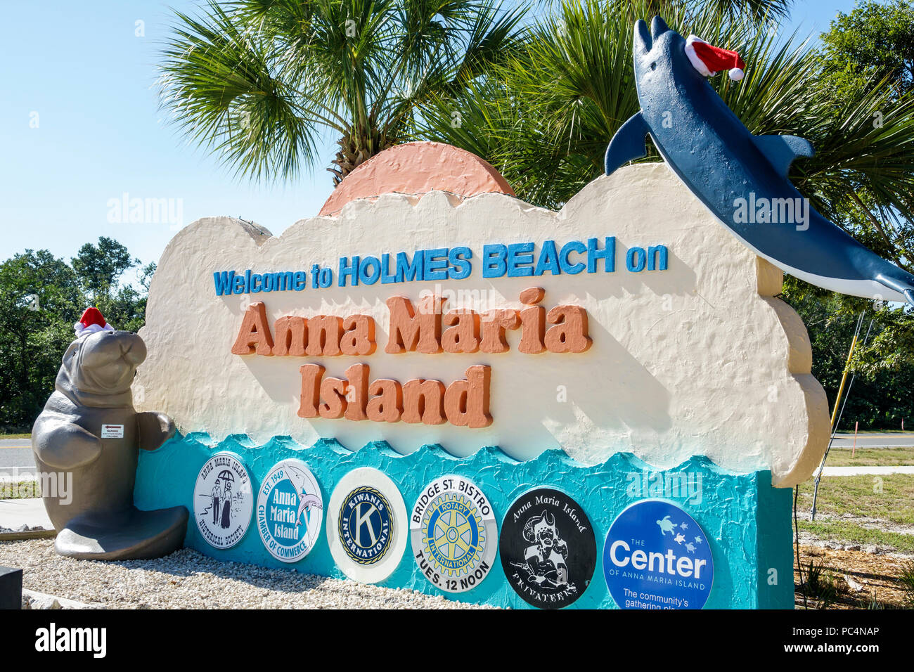 Florida,isola di Anna Maria,Spiaggia di Holmes,cartello di benvenuto,camera di commercio,Kiwanis,Rotary Club,decorazione di vacanza,cappello di Santa,scultura di lamantini,FL171212052 Foto Stock