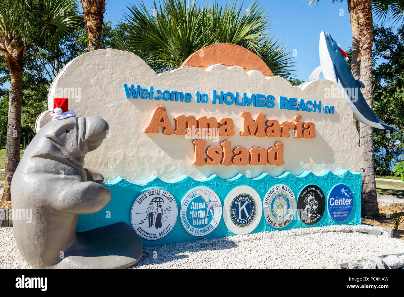 Florida,isola di Anna Maria,Spiaggia di Holmes,cartello di benvenuto,camera di commercio,Kiwanis,Rotary Club,decorazione di vacanza,cappello di Santa,scultura di lamantini,FL171212053 Foto Stock