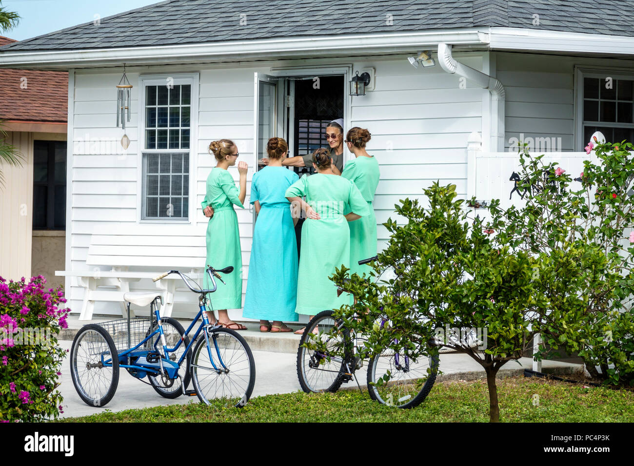 Sarasota Florida,Pinecraft Pine Craft Amish Mennonite comunità,casa casa teen teen adolescenti ragazze amici in visita vicino biciclette triciclo Foto Stock