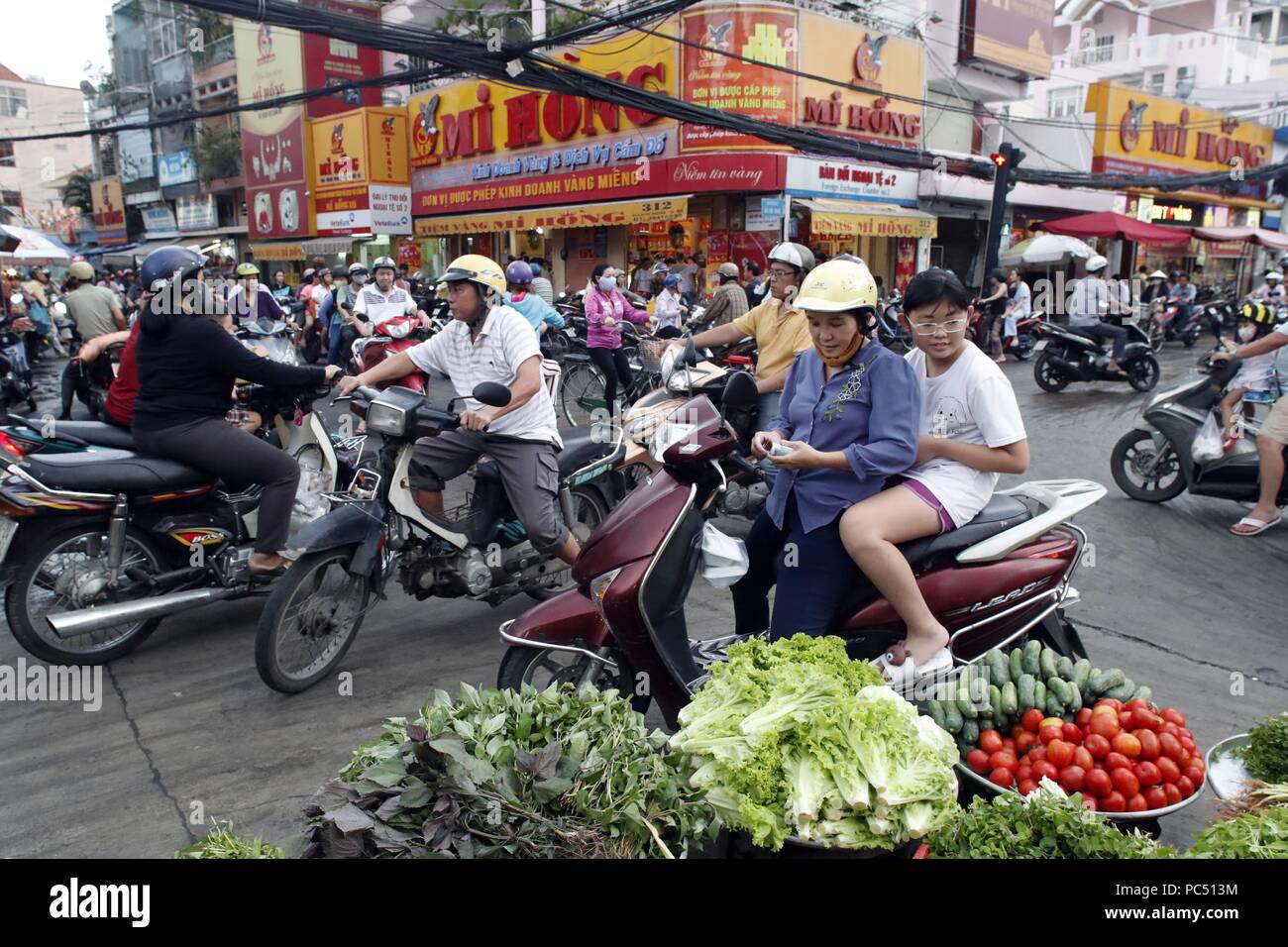 Mercato e le motociclette su strada caotica vita traffico. Ho Chi Minh City. Il Vietnam. | Utilizzo di tutto il mondo Foto Stock