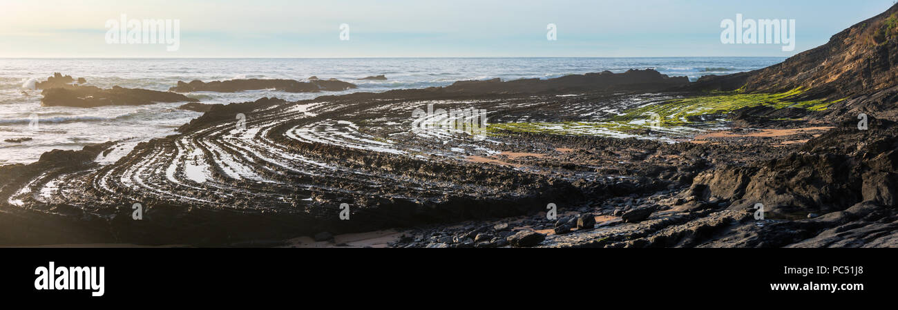 Anfiteatro naturale (curve lapideo) sulla spiaggia Carriagem a bassa marea (Aljezur, Algarve, Portogallo). Foto Stock