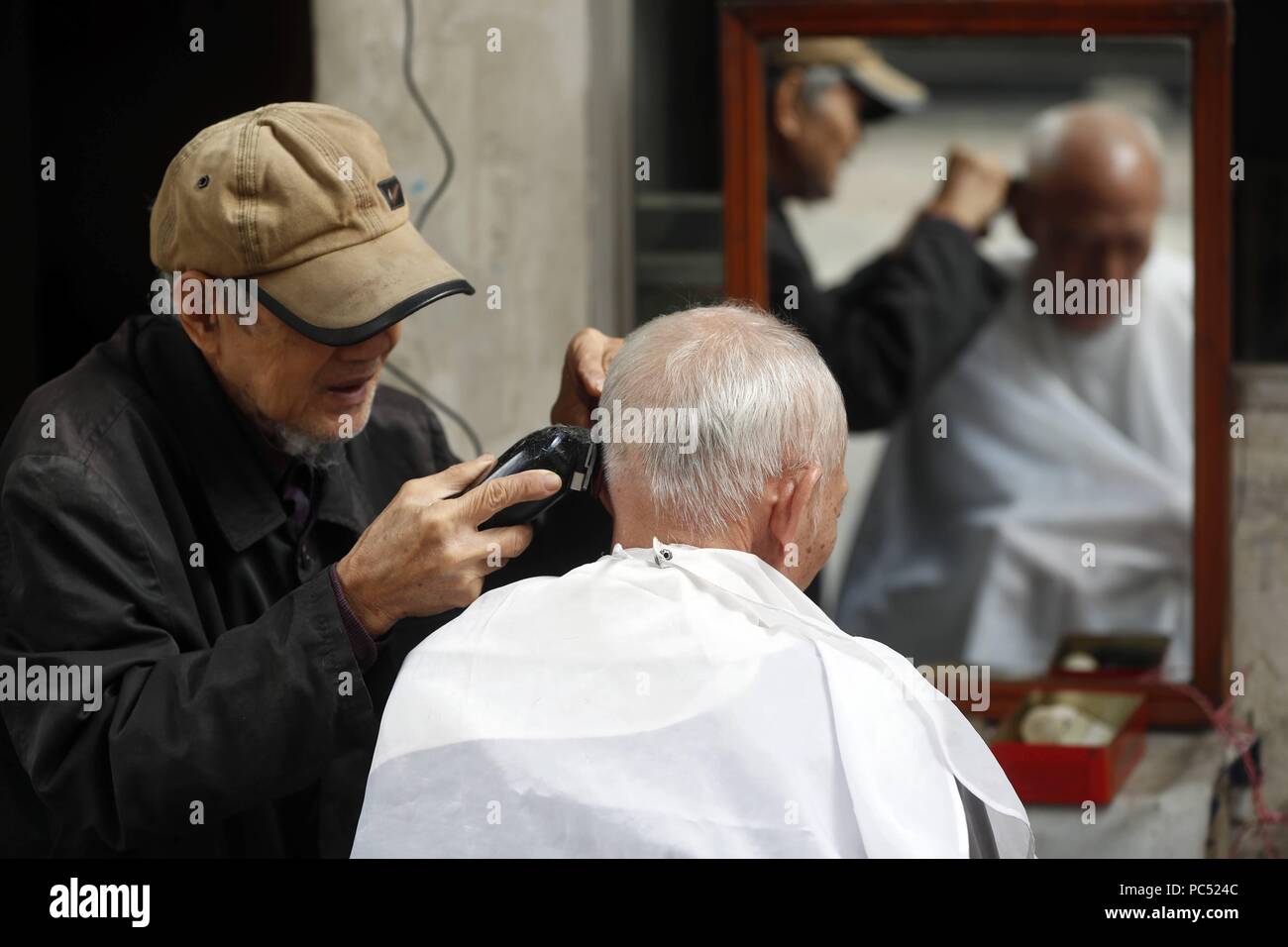 Barbiere di strada nel quartiere vecchio. Hanoi. Il Vietnam. | Utilizzo di tutto il mondo Foto Stock