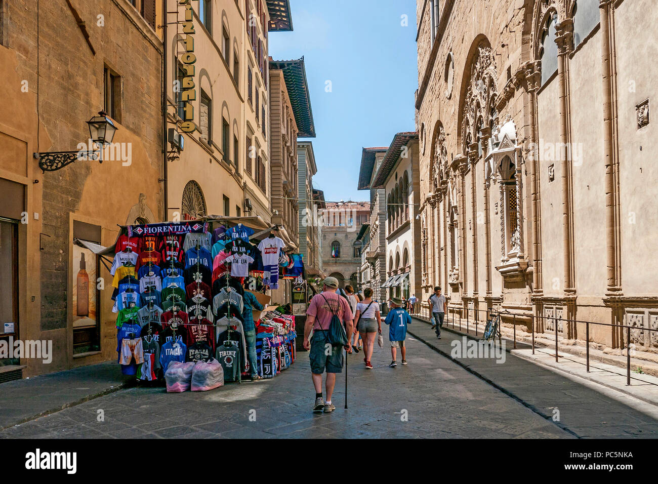 Le persone che ricercano le bancarelle del mercato in una via medievale in Firenze, Toscana, Italia Foto Stock
