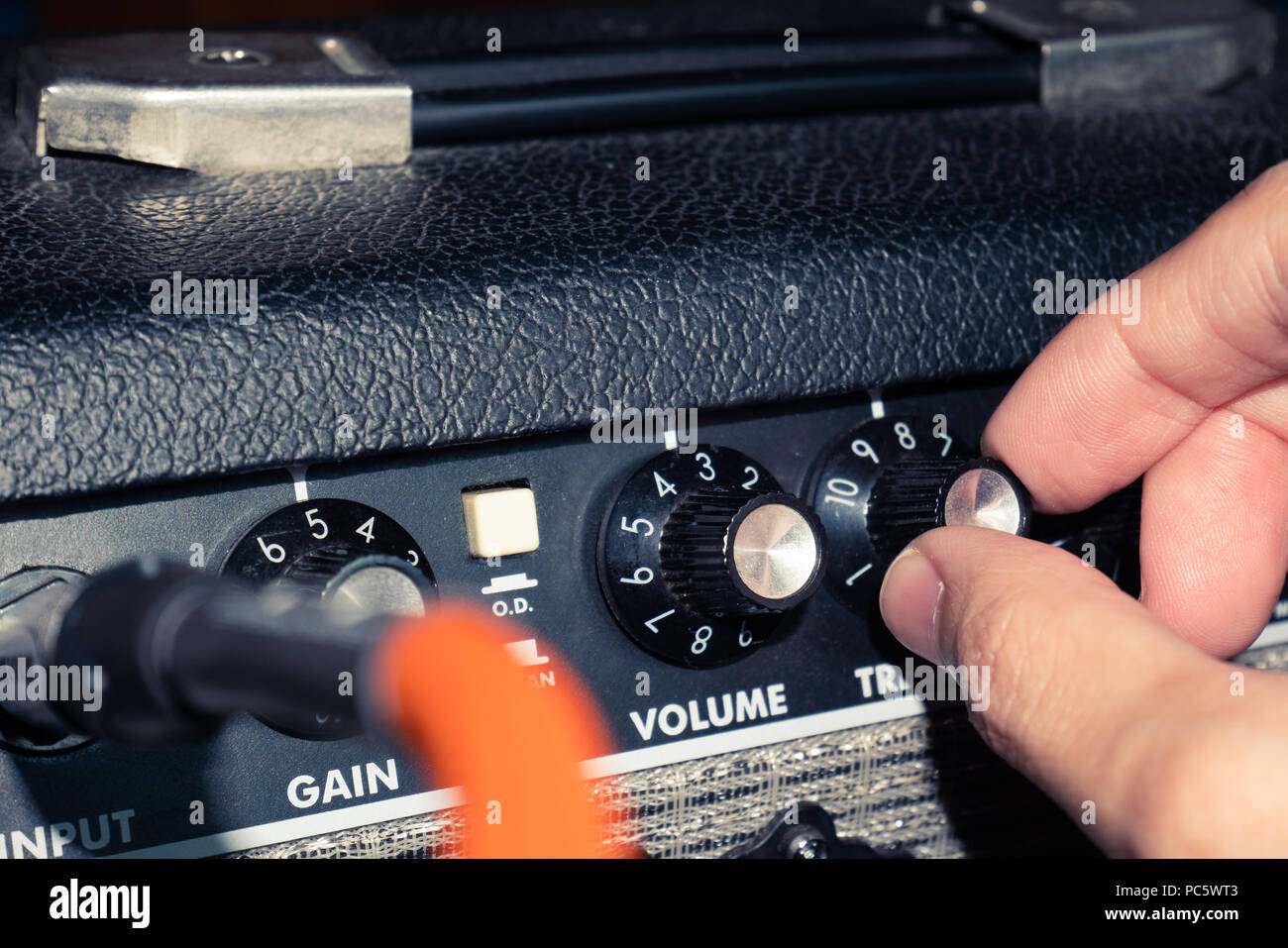 Immagine ravvicinata di mano la regolazione amplificatore per chitarra la  manopola di controllo Foto stock - Alamy