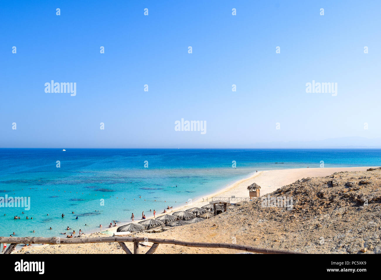 Vista su Mahmya isola, belle paradiso nel mare rosso, oceano turchese, ombrelloni presso la spiaggia di sabbia, cielo blu e alcuni turisti Foto Stock