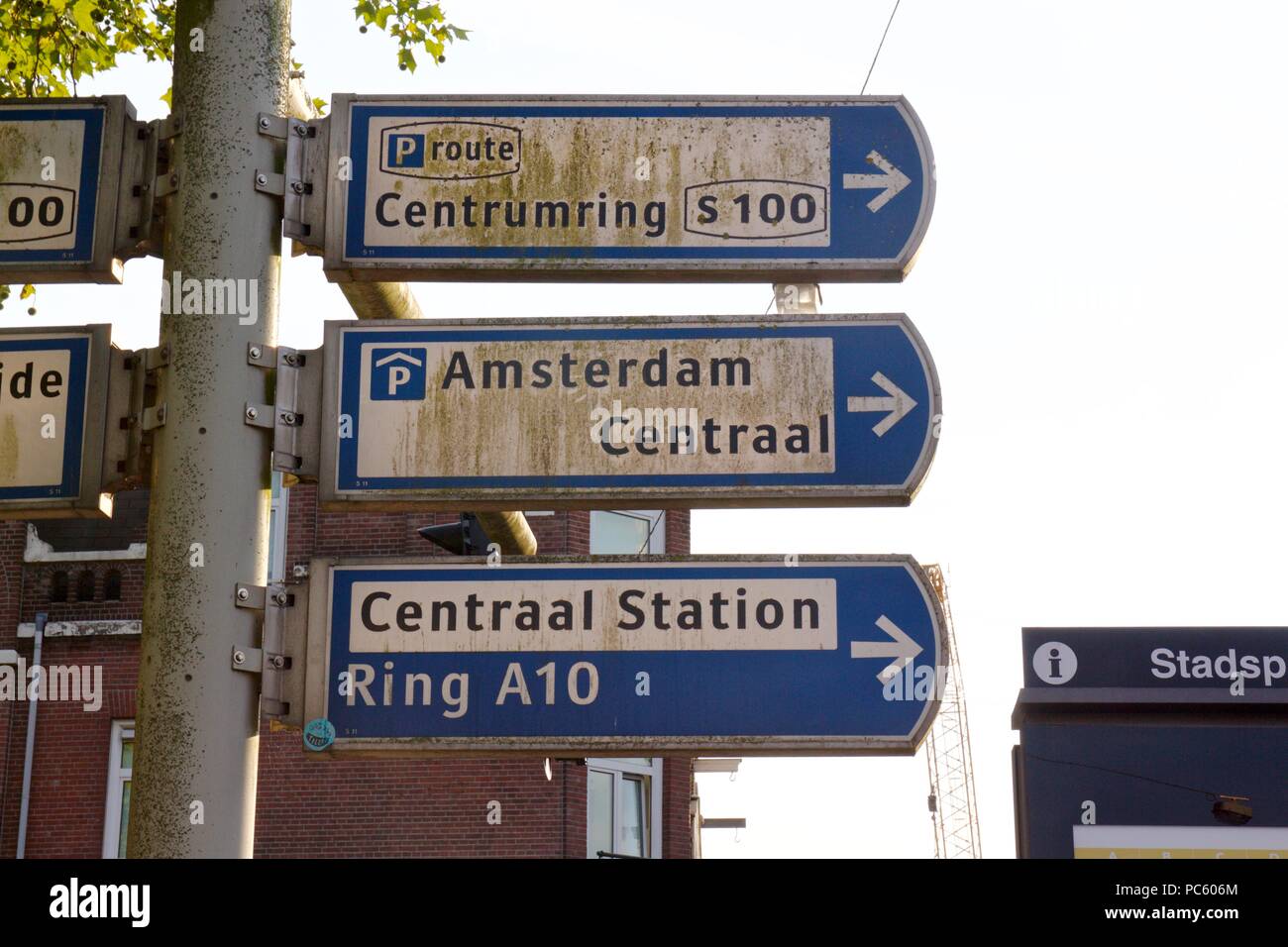 Tre blu e segni bianchi su un montante metallico per le direzioni in Amsterdam, incluso per Amsterdam Centraal Foto Stock