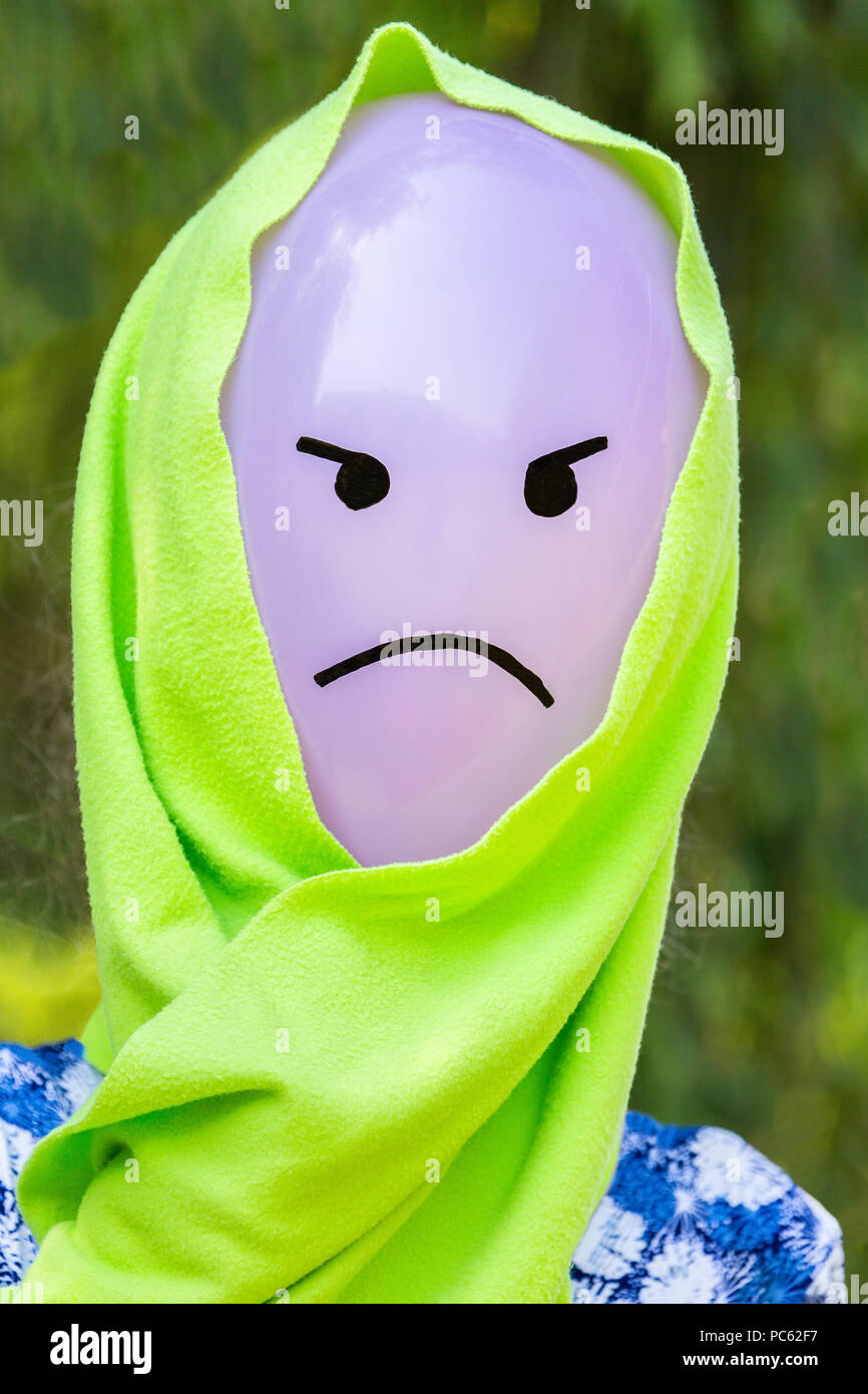 Palloncino in testa con arrabbiato espressione facciale indossando scialle verde Foto Stock