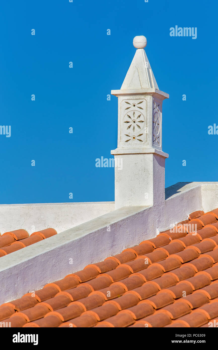 Grazioso camino bianco sul tetto con tegole di colore arancione Foto Stock