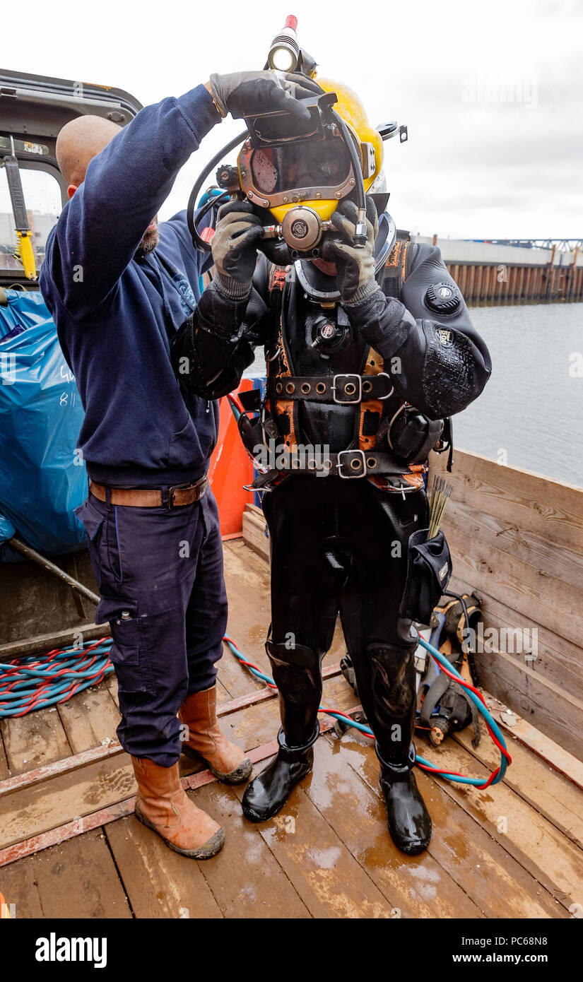 Amburgo, Germania. Il 26 giugno, 2018. Un collega aiuta Mat Goy (r), il professionista subacqueo nel porto di Amburgo, togliere il casco dopo un sottomarino di operazione di saldatura. Credito: Markus Scholz/dpa/Alamy Live News Foto Stock