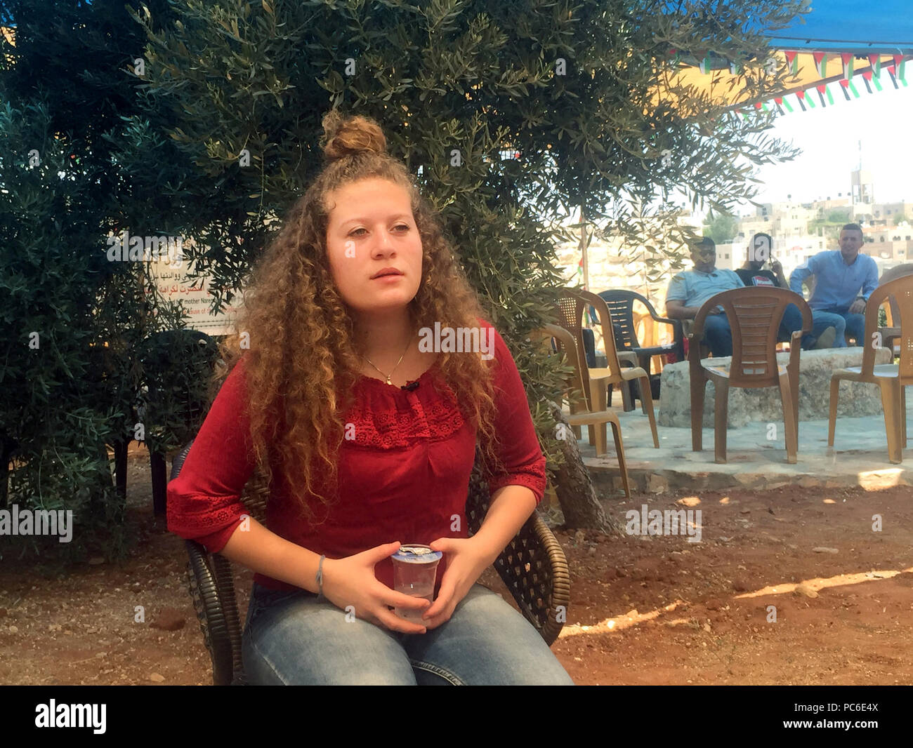 Il 31 luglio 2018, West Bank, Nabi Saleh: Ahed Tamimi si siede nella sua famiglia giardino sotto un albero di olivo. Quasi otto mesi in un carcere israeliano hanno derubato il suo di parte della sua giovinezza, dice il 17-anno-vecchio palestinese. Tuttavia, lei non rammarico per l'attacco di un soldato. Foto: Sara Lemel/dpa Foto Stock