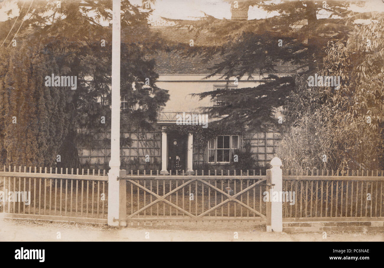 L'annata 1905 Cartoline fotografiche di un Edwardian Lady e il bambino si fermò alla porta di una grande casa. Postato da Halstead Foto Stock