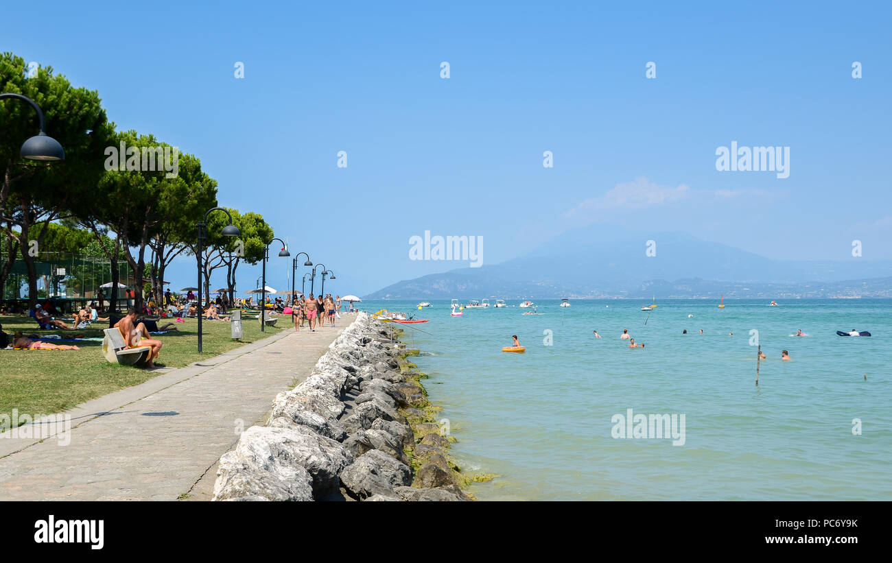 La spiaggia pubblica al lago di Garda su un bel giorno di estate Foto Stock