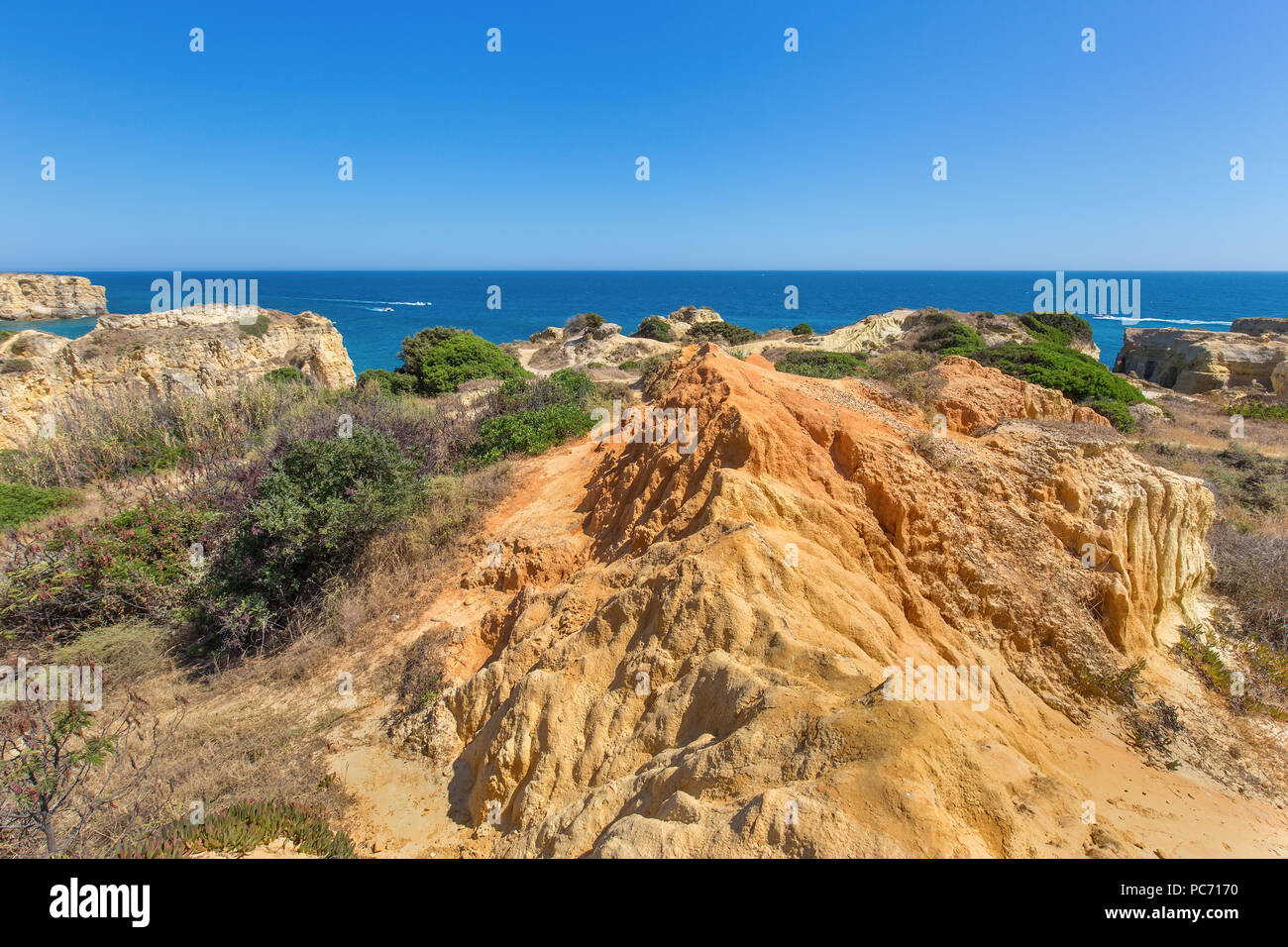 Orange montagne rocciose e piante verdi a riva in Portogallo Foto Stock