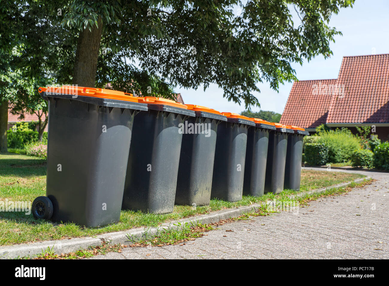 Riga di grigio dei contenitori per i rifiuti di materiale di confezionamento lungo la strada Foto Stock